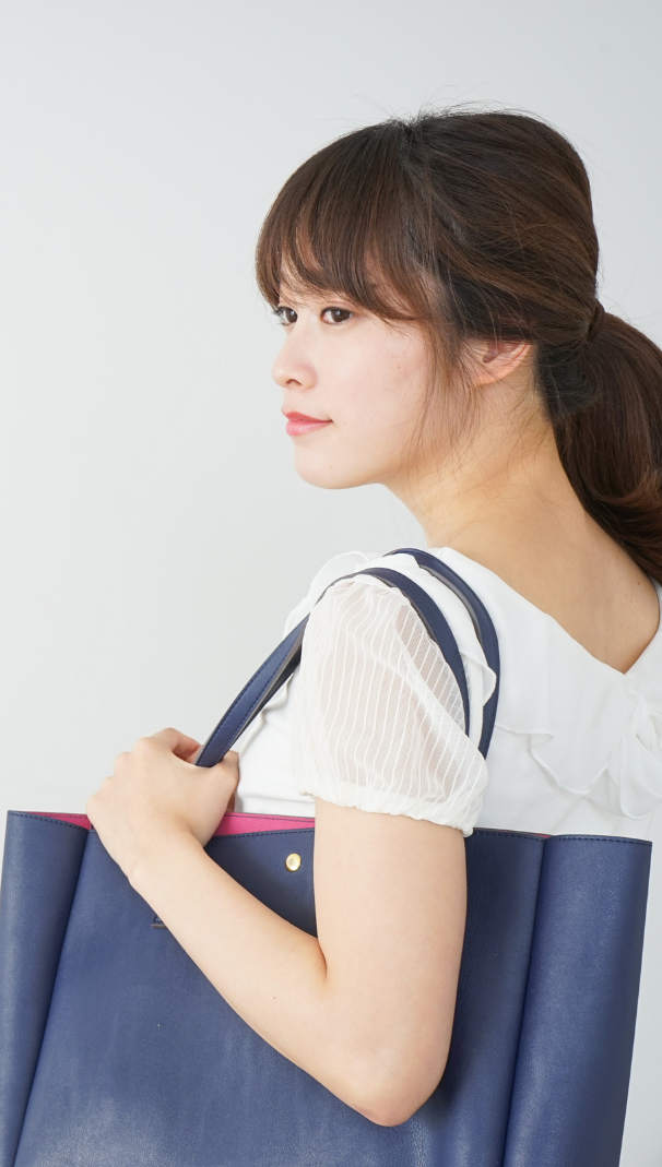 model holding shoulder bag